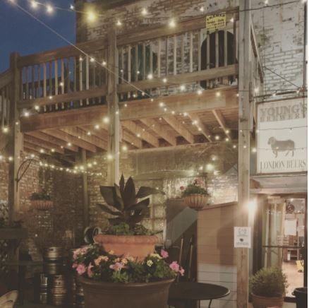 Image of the duke of Perth’s new outdoor decorations lights are hung up, and fresh potted plants and flowers are situated in front.