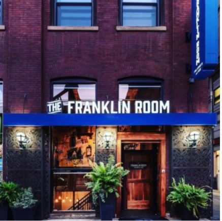 franklin room’s facade with the lights on inside and with the lamps on the outside